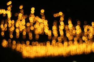 out of focus yellow lights create a bokeh effect at wisley glow in the enchanting rhs garden.